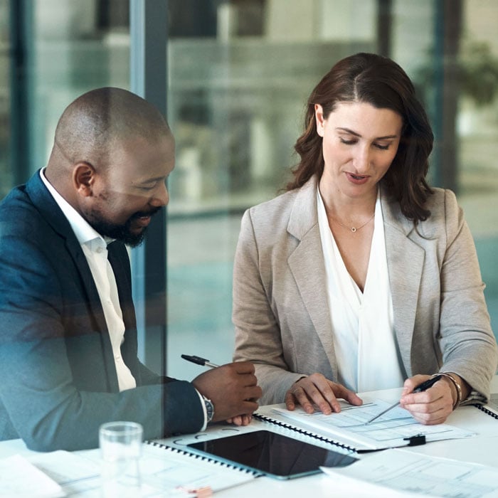 Two colleagues reviewing financing paperwork at a table