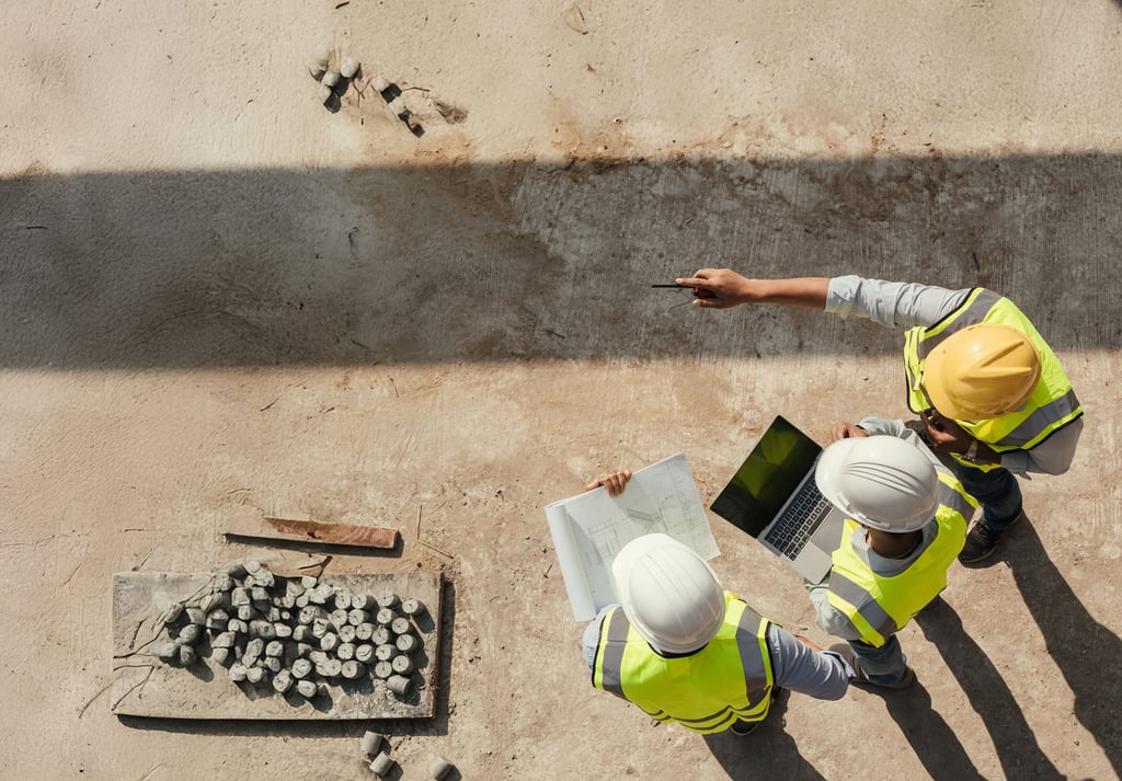 Construction workers reviewing plans on a laptop