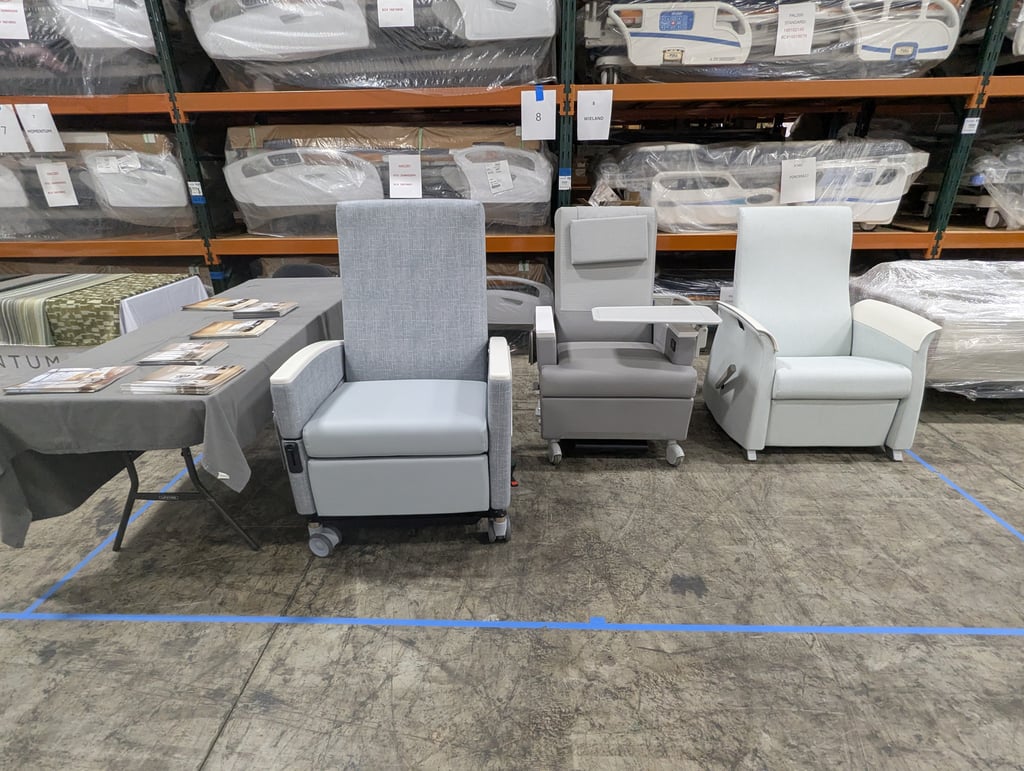 Three grey medical recliners lined up at the Wieland booth, number 8, with wrapped hospital beds behind