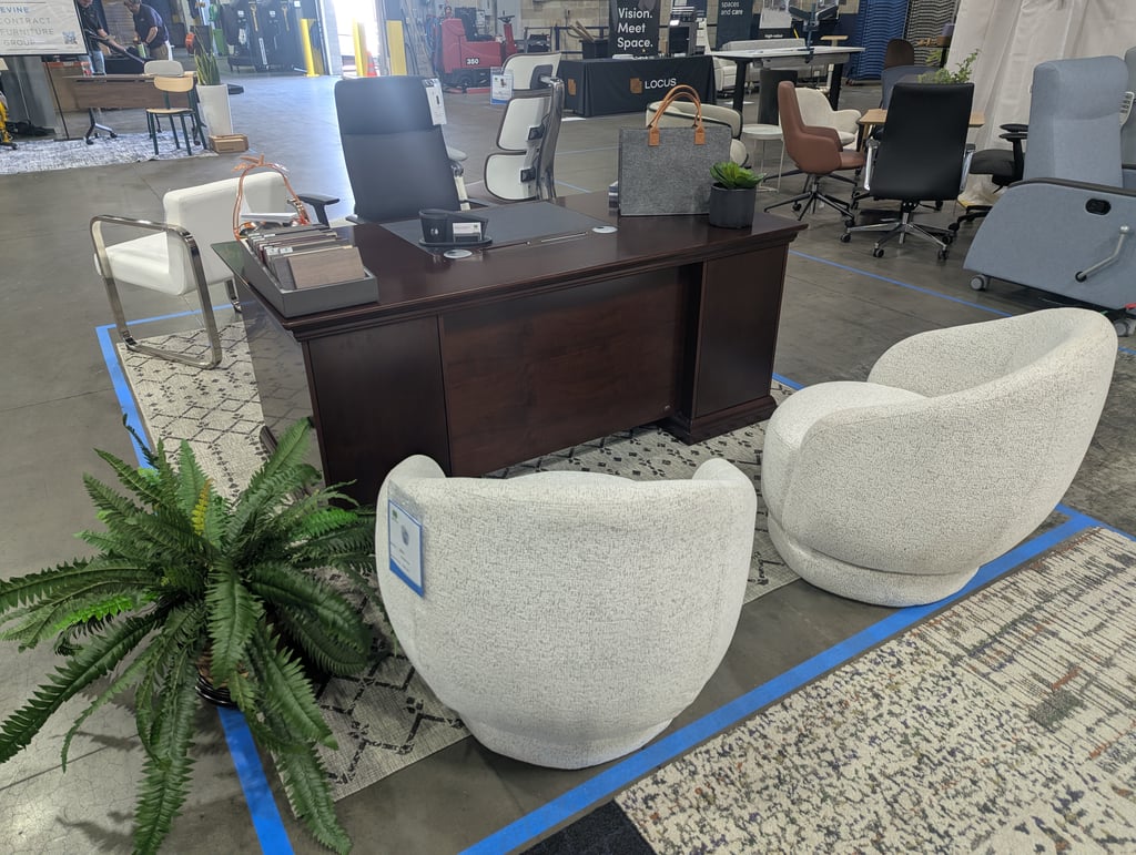A dark wood desk and upholstered swivel chairs under the Locus banner reading Vision. Meet Space.