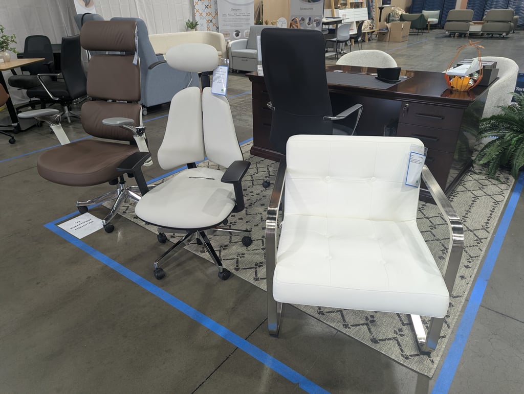 White, brown and black office chairs arranged around a dark wood desk beneath Sleepers and Accessories signs