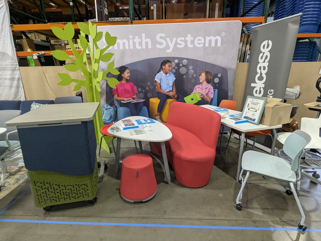 Colourful soft seating and a stylised green tree prop in front of the Smith System backdrop