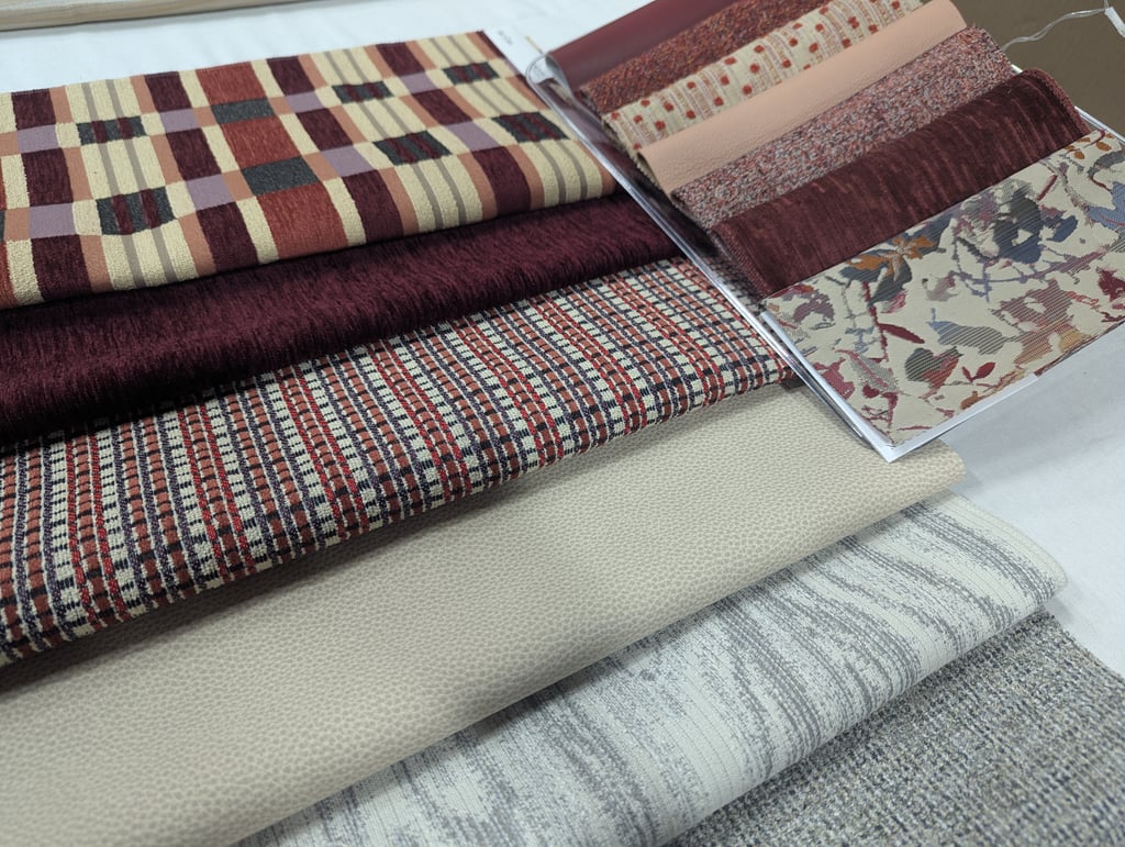 Fanned fabric swatches in burgundy plaid, small check, floral and neutral leather-look textures