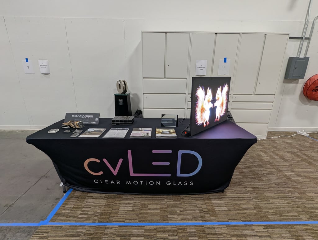 The cvLED Clear Motion Glass table with an upright LED panel showing a flame image, brochures and samples