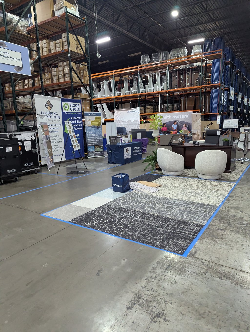 Carpet samples laid on the floor between the Floor Cycle, Flooring Foundation and Smith System stands