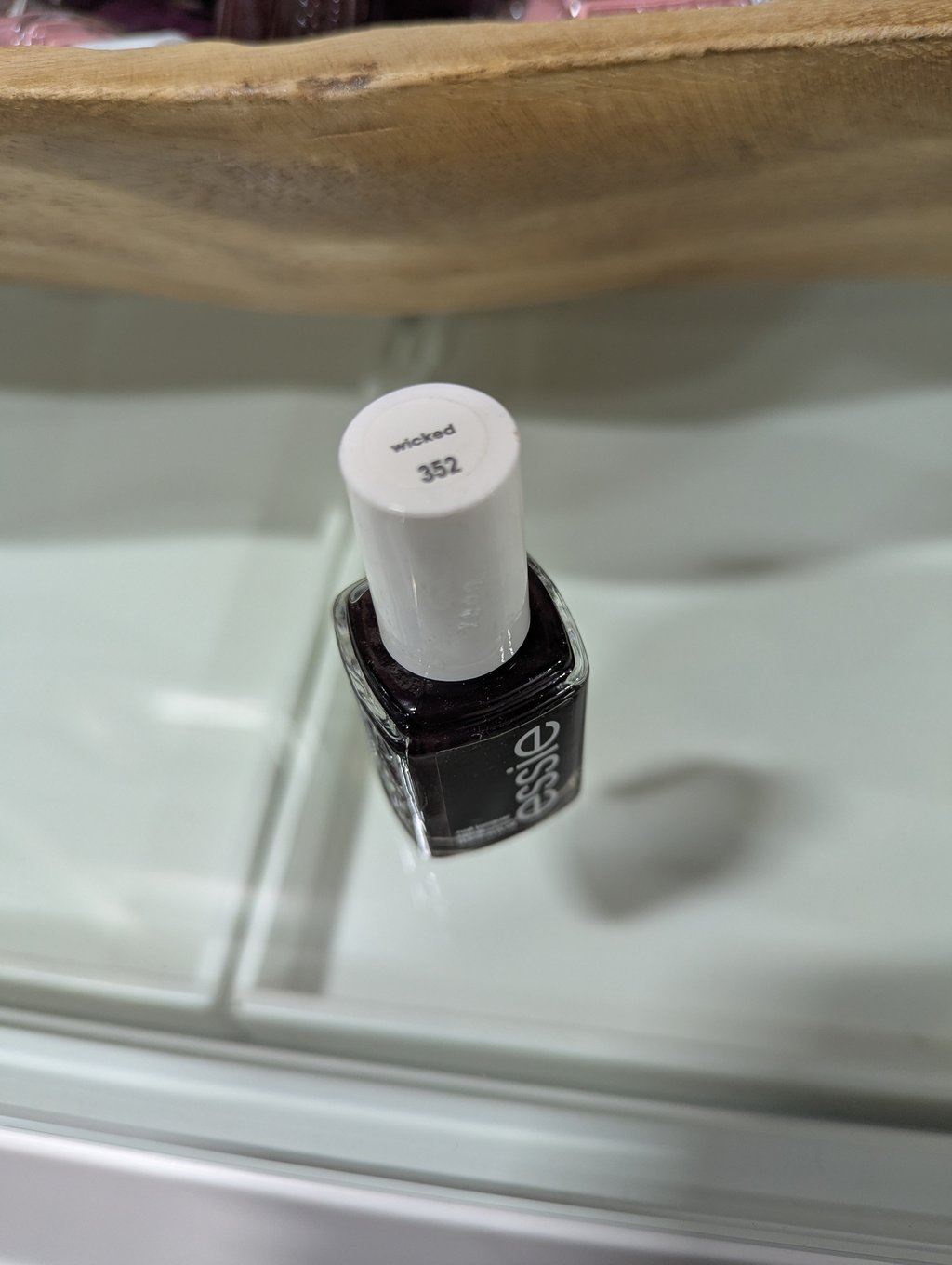 A close view of a dark Essie nail polish bottle used as a colour reference