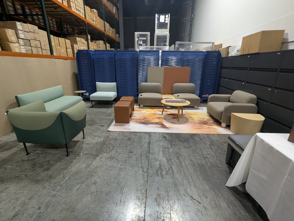 A lounge setting of sofas, ottomans and a round wooden coffee table on a patterned rug beside tall blue crates