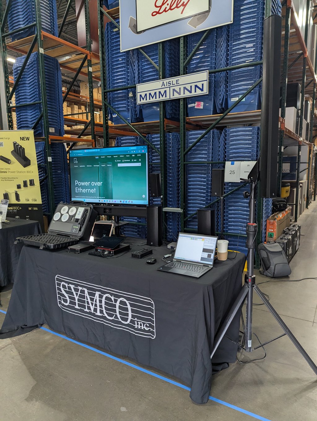 Audio and computer equipment on the Symco demo table with a monitor showing Power over Ethernet