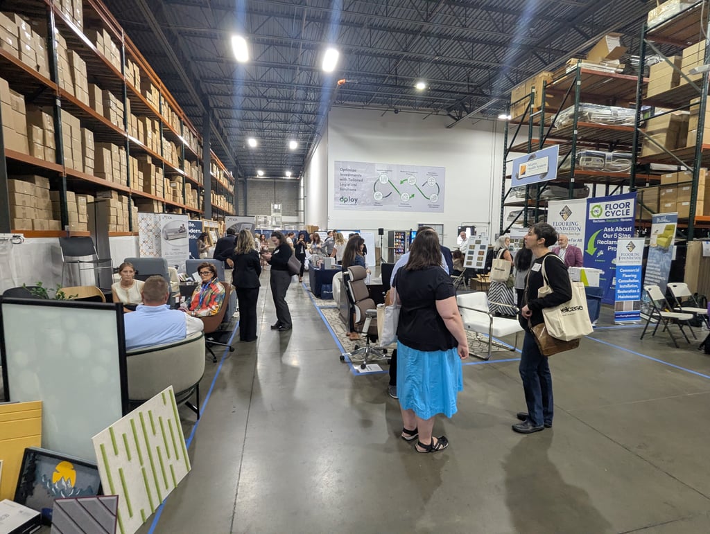 A wide view of the event floor with the Floor Cycle and Flooring Foundation booths and a large dploy logistics poster
