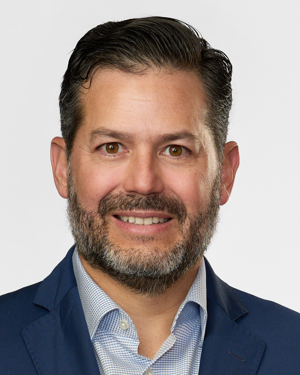 photo of Pablo Berckholtz wearing dark suit with multi coloured tie