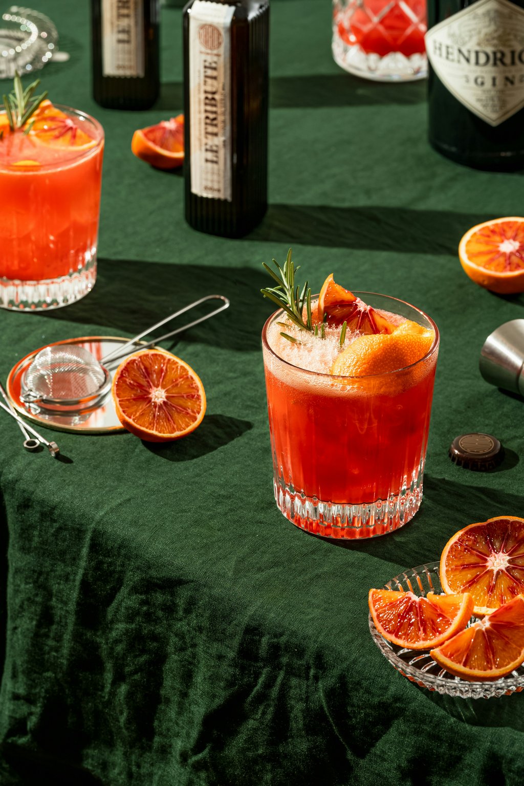 Two blood orange cocktails garnished with rosemary and orange slices