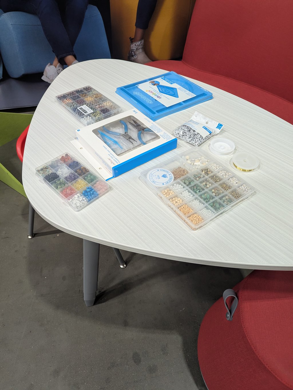 Bead trays, wire spools and pliers laid out for a hands-on making activity