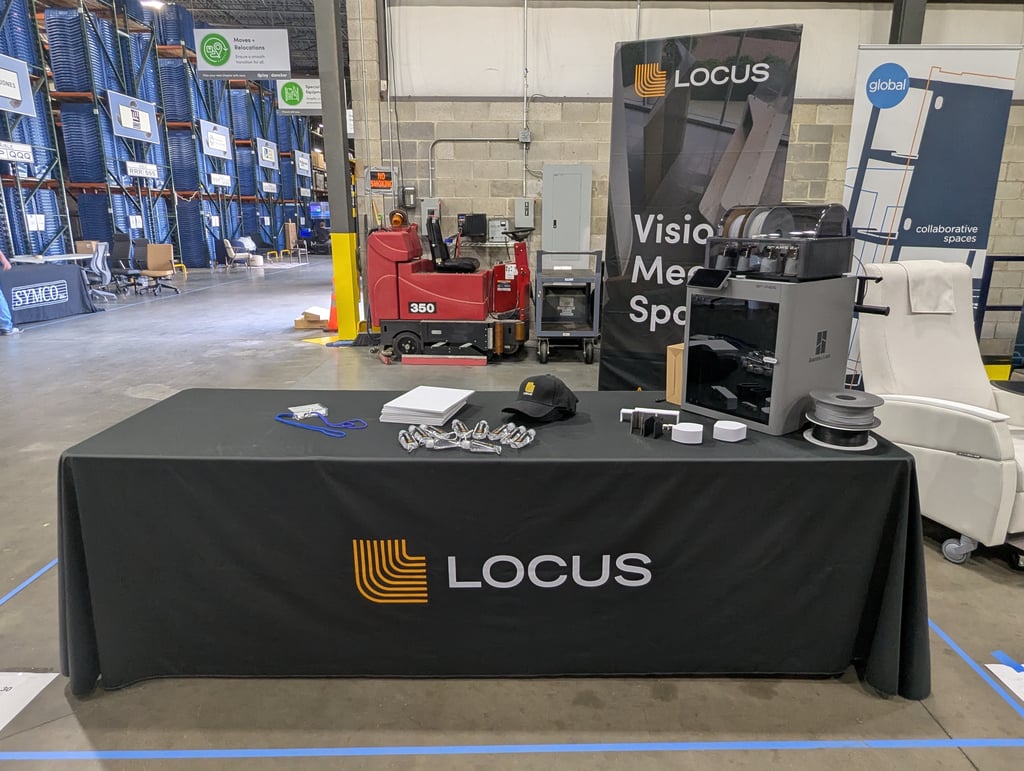 The Locus exhibit table and banner set against warehouse storage racking