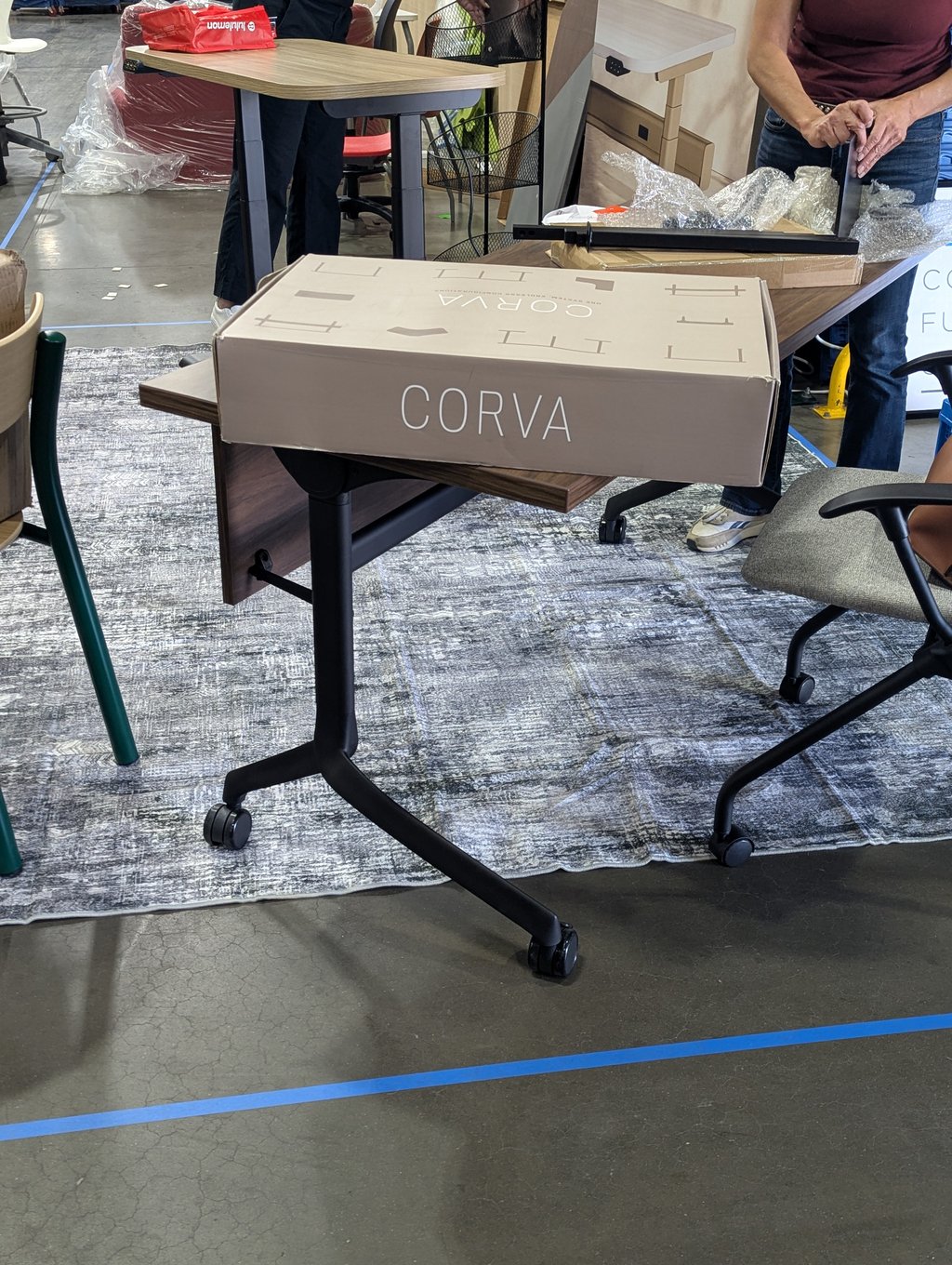 A Corva carton on a part-assembled table with adjustable legs and casters