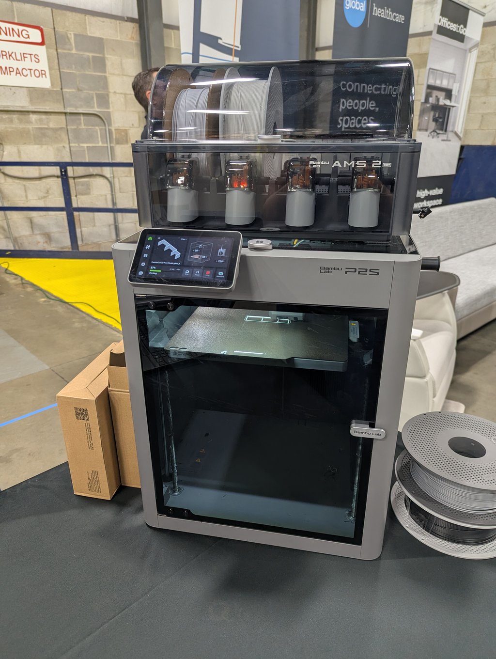 A Bambu Lab P2S 3D printer with a multi-spool filament feeder running a print