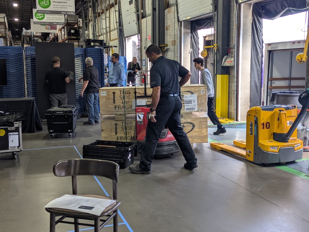 Crew unloading stacked wooden crates at the warehouse loading dock