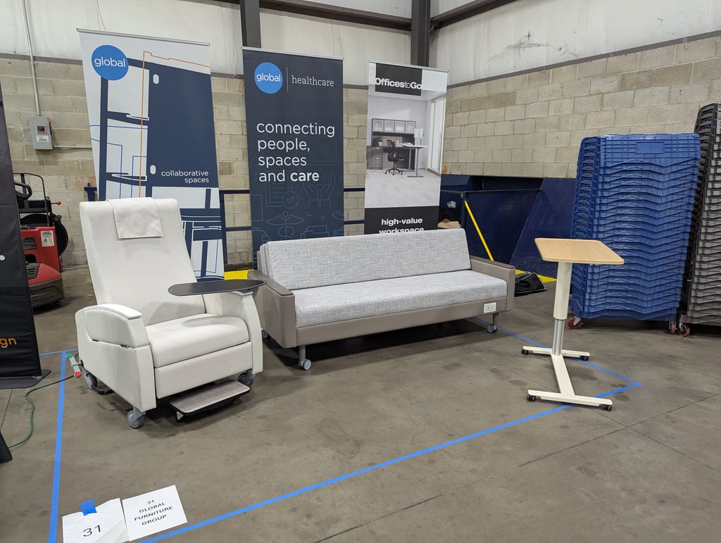 Medical seating and a rolling table in front of the Global healthcare banners