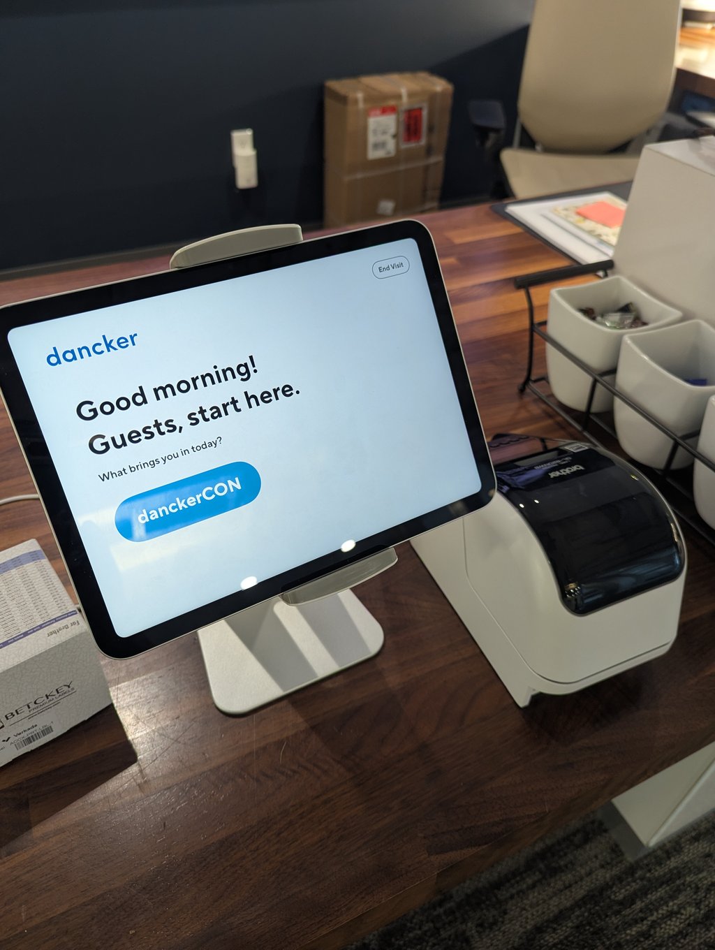 A guest check-in tablet on the reception desk showing the danckerCON sign-in button