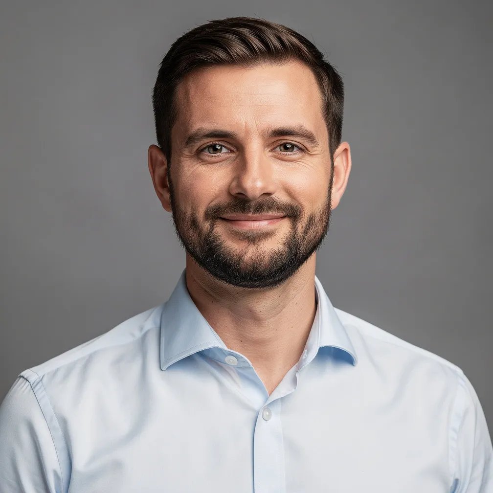 Professional headshot of a bearded man in a blue shirt
