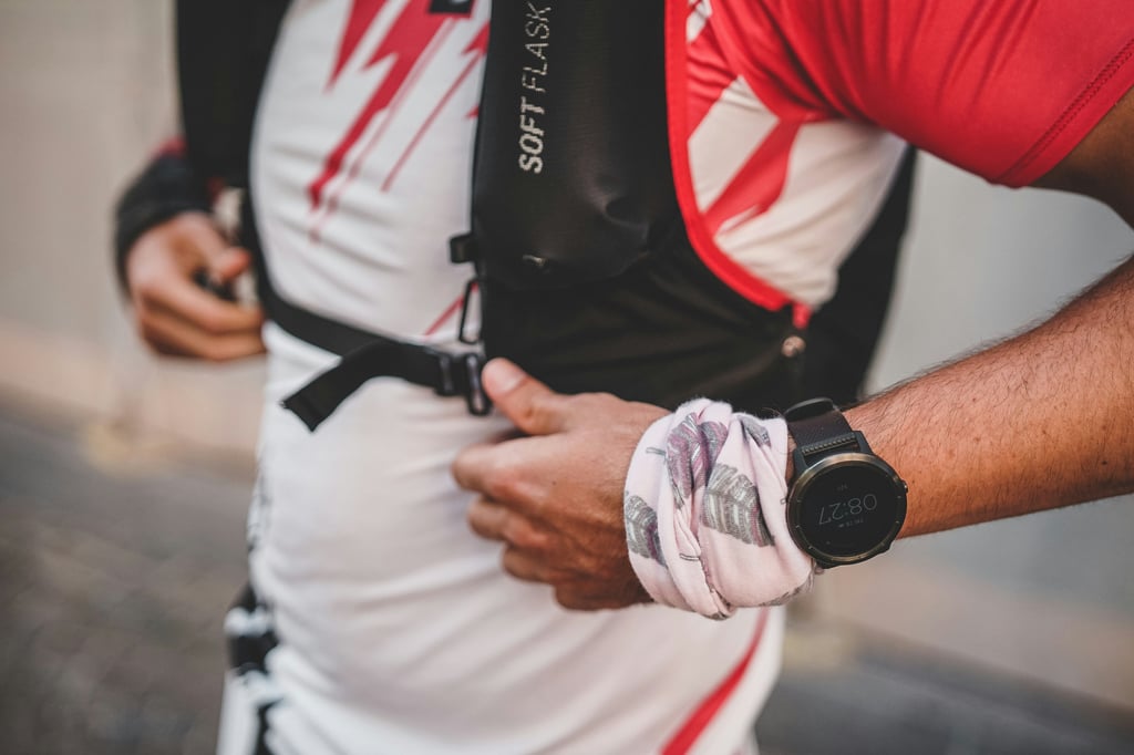 Athlete fastening a chest strap, sports watch on the wrist