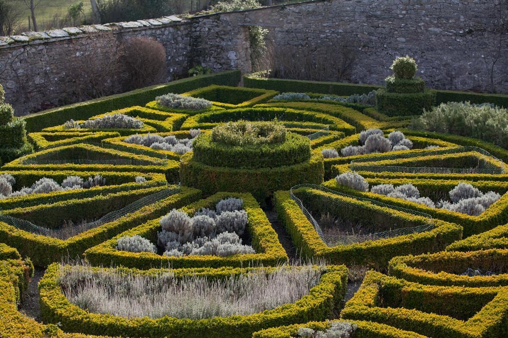 Aerial view of Bodysgallen's 17th-century parterre in winter, with its winding formal garden design.