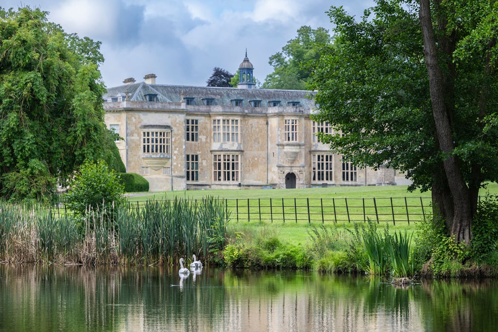View of Hartwell House across a lake with wildlife in the foreground.