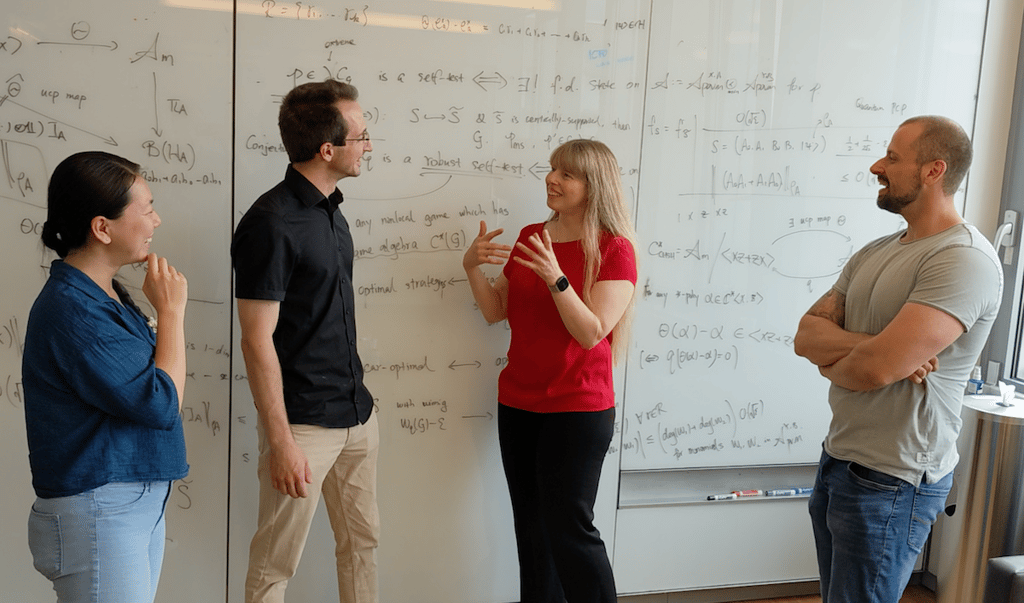 Dr. Christine Muschik and researchers discussing ideas in front of a white board.